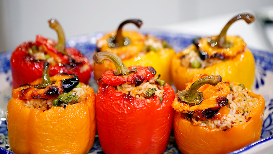 Sweet mini roasted capsicums topped with thyme leaves on a white plate.